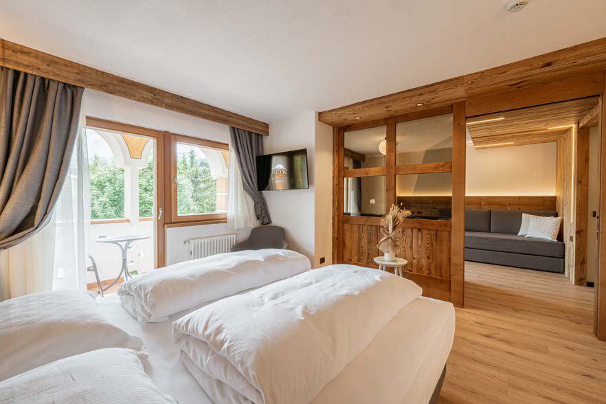 Camera d'albergo con letto matrimoniale e arredi in legno
