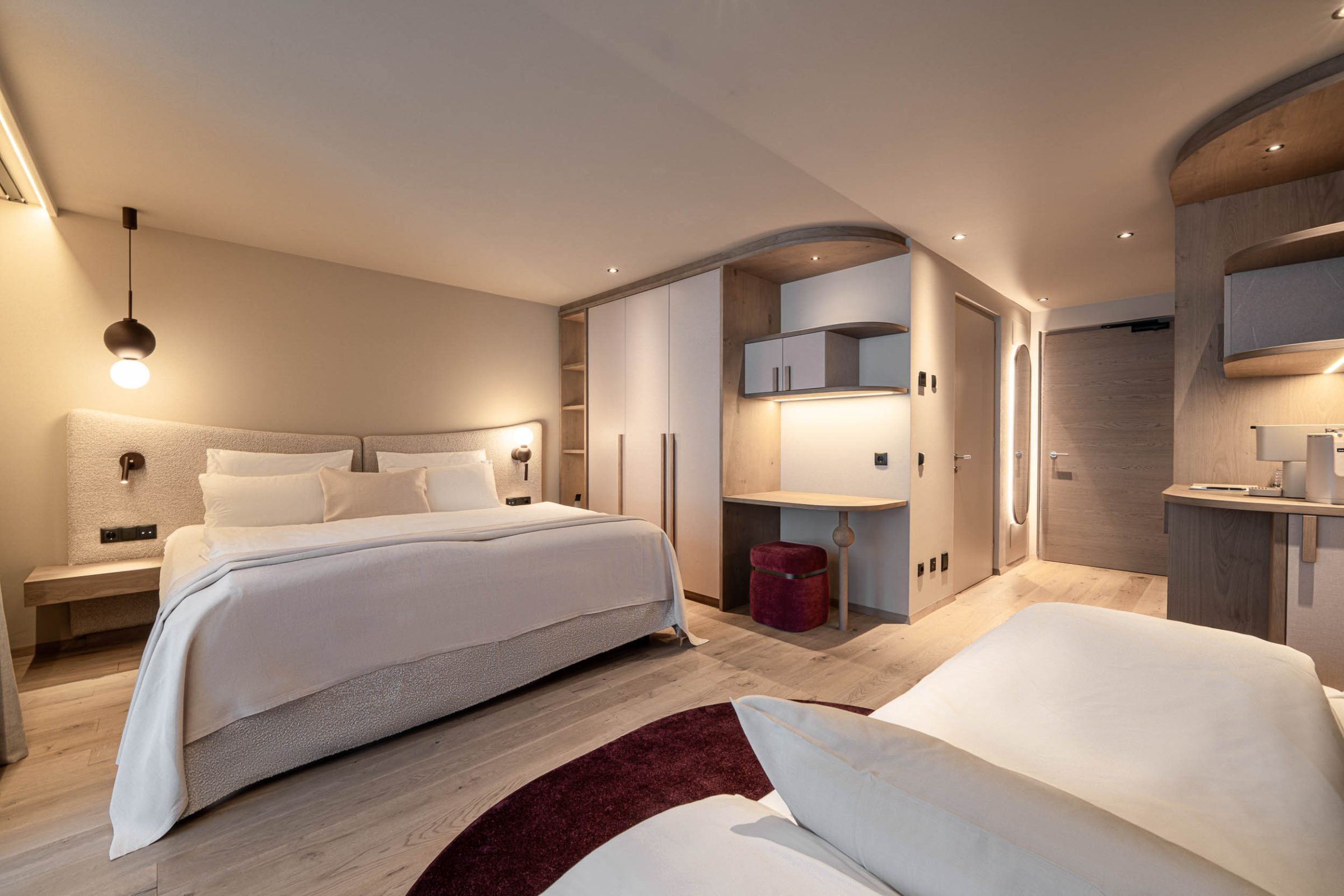 Camera d'albergo con letto matrimoniale e arredi chiari