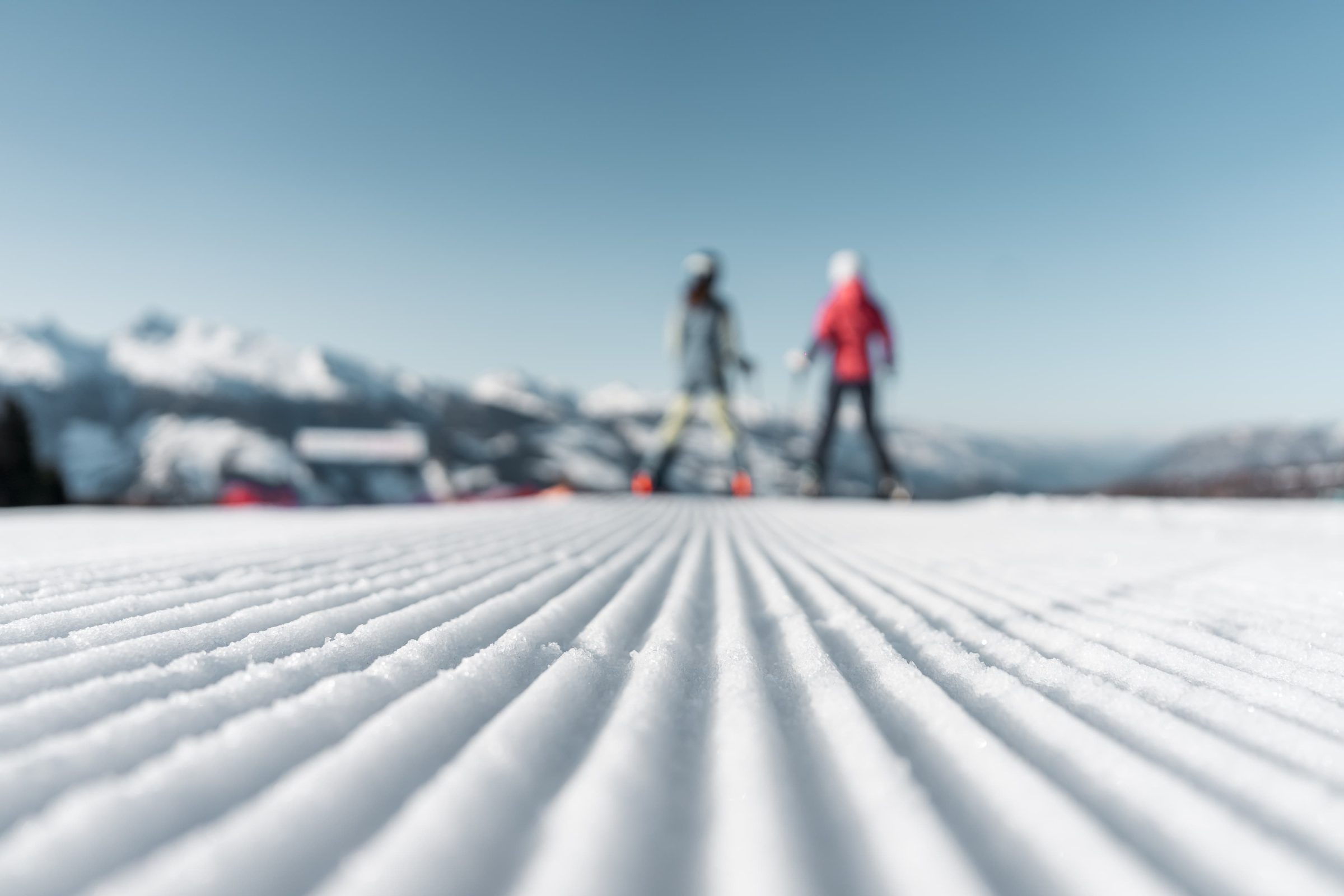 Due figure in lontananza su una distesa di neve appena battuta