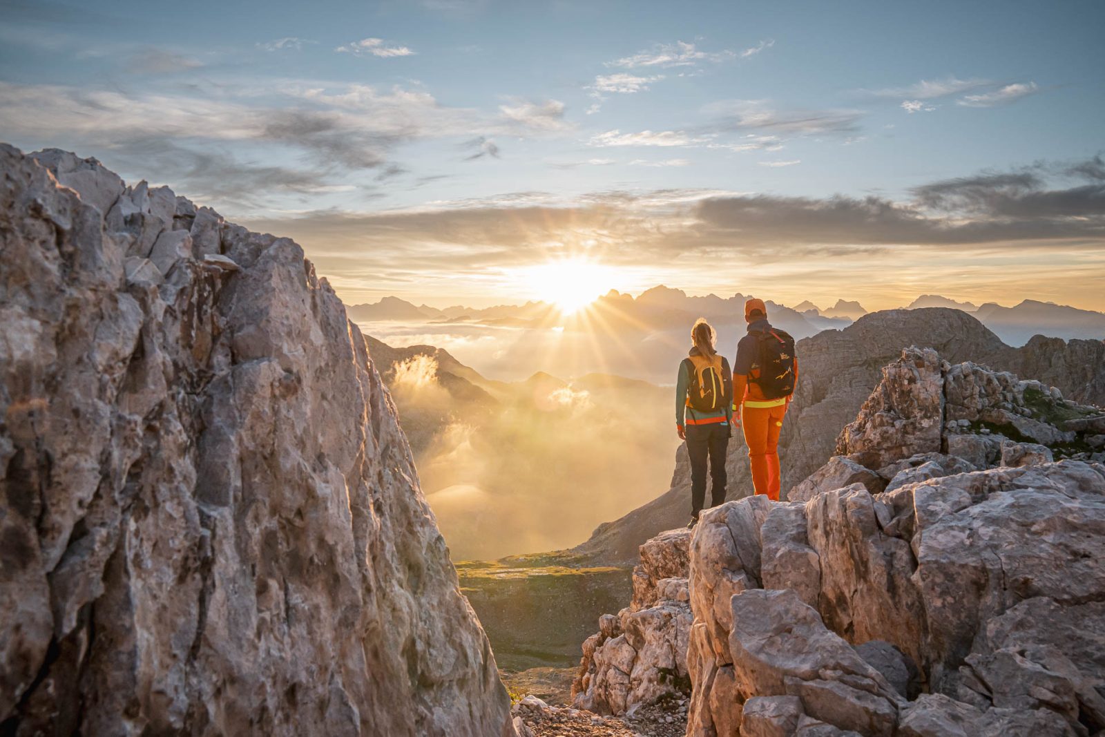 Escursionisti in cresta con il sole che filtra tra le rocce