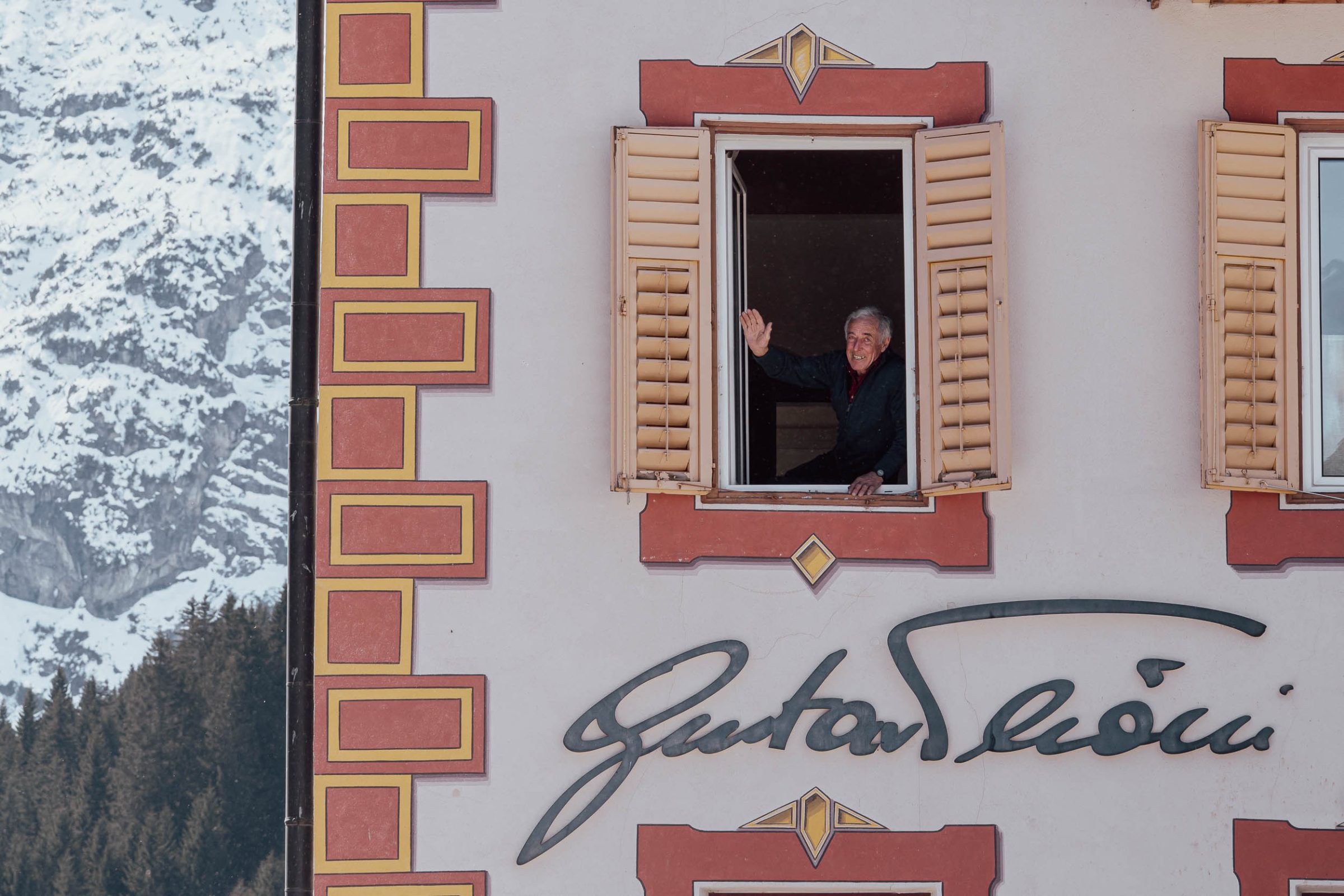 Finestra con cornice affrescata sulla facciata di una casa alpina