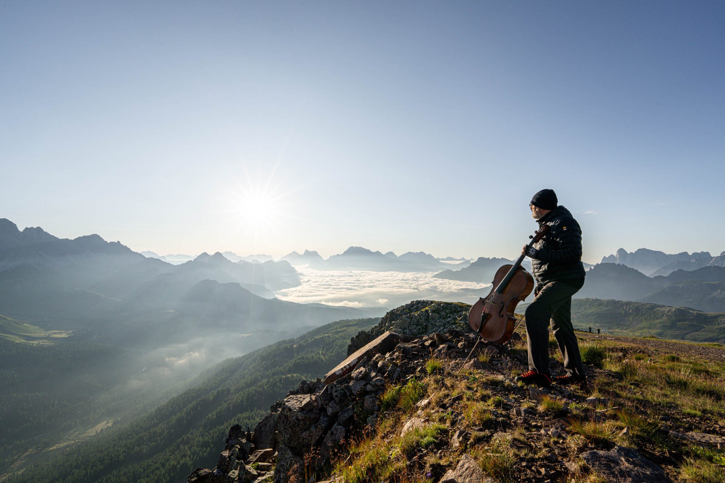 Fotografo con treppiede in cresta durante l'alba sulle Dolomiti