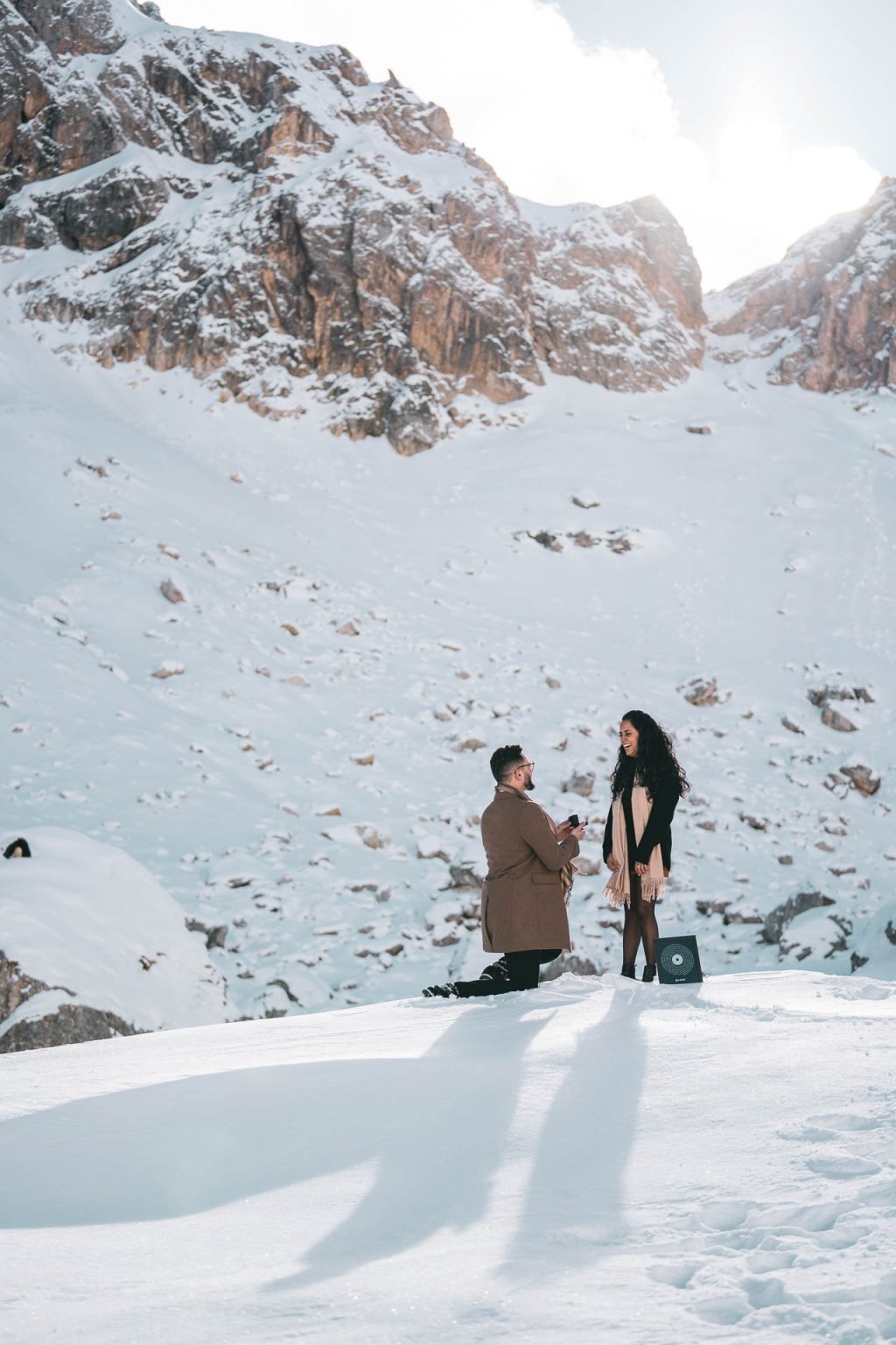 Proposta di matrimonio in ginocchio su un pendio innevato