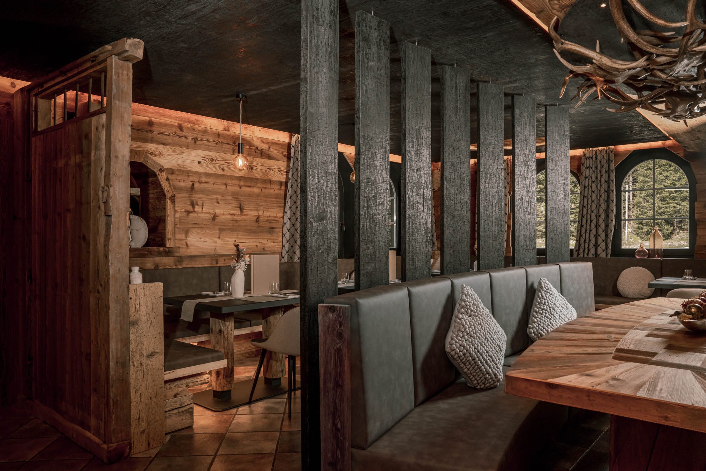 Sala di un rifugio con arredi in legno e sedute morbide