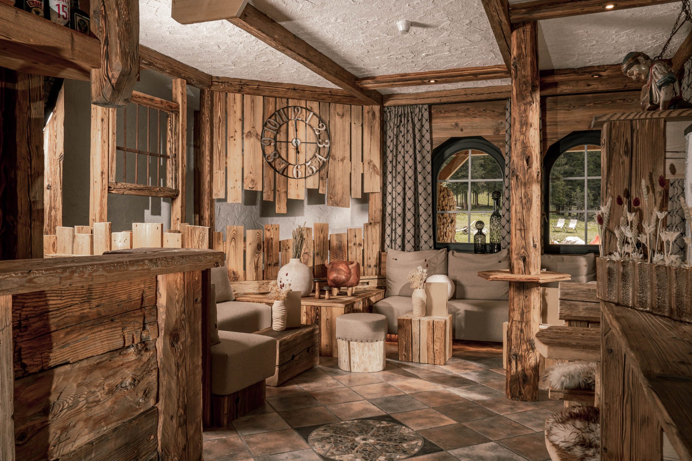 Salotto di un hotel di montagna con poltrone e rivestimenti in legno