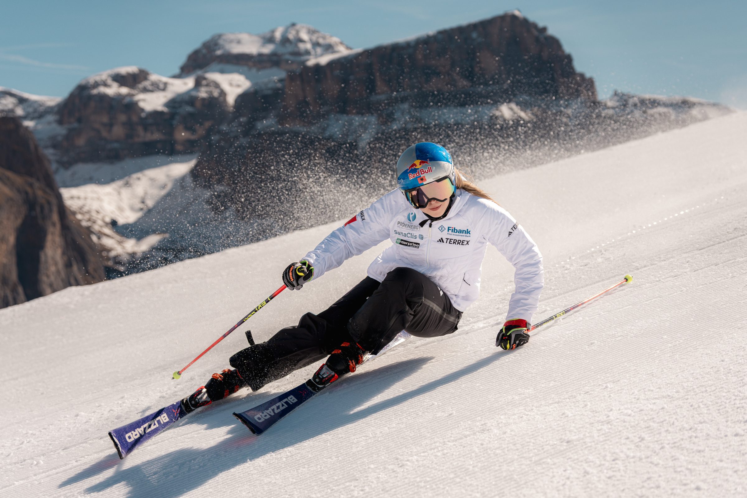 Sciatore agonista solleva uno spruzzo di neve affrontando una curva
